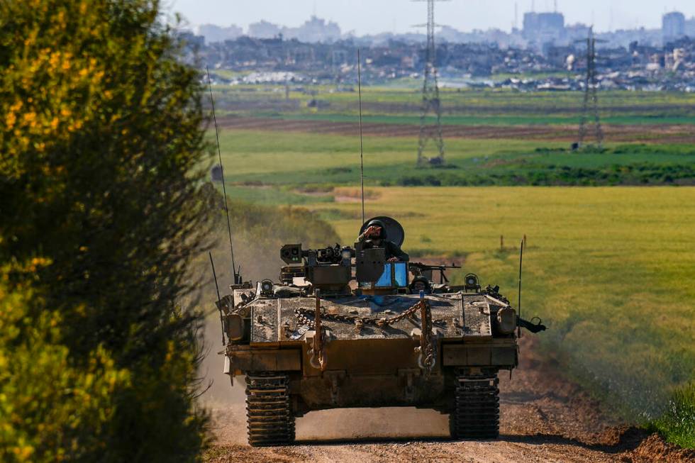 Israeli soldiers drive an APC near the border with Gaza Strip, in southern Israel, Sunday, Marc ...