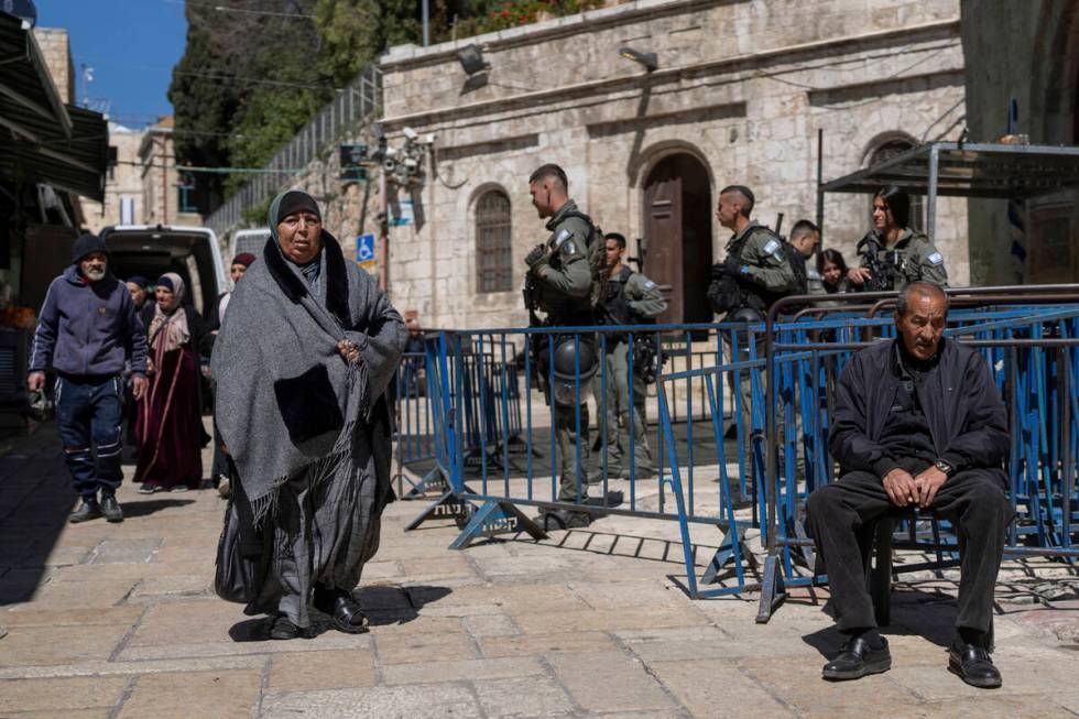 Israeli border police officers stand guard as Palestinians walk by in Jerusalem's Old City on t ...