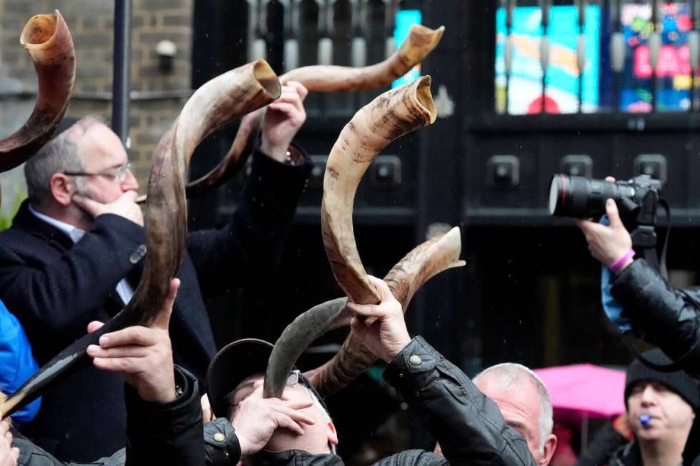 Jewish people and sympathisers blow shofars (ram's horns of spiritual significance) and whistle ...