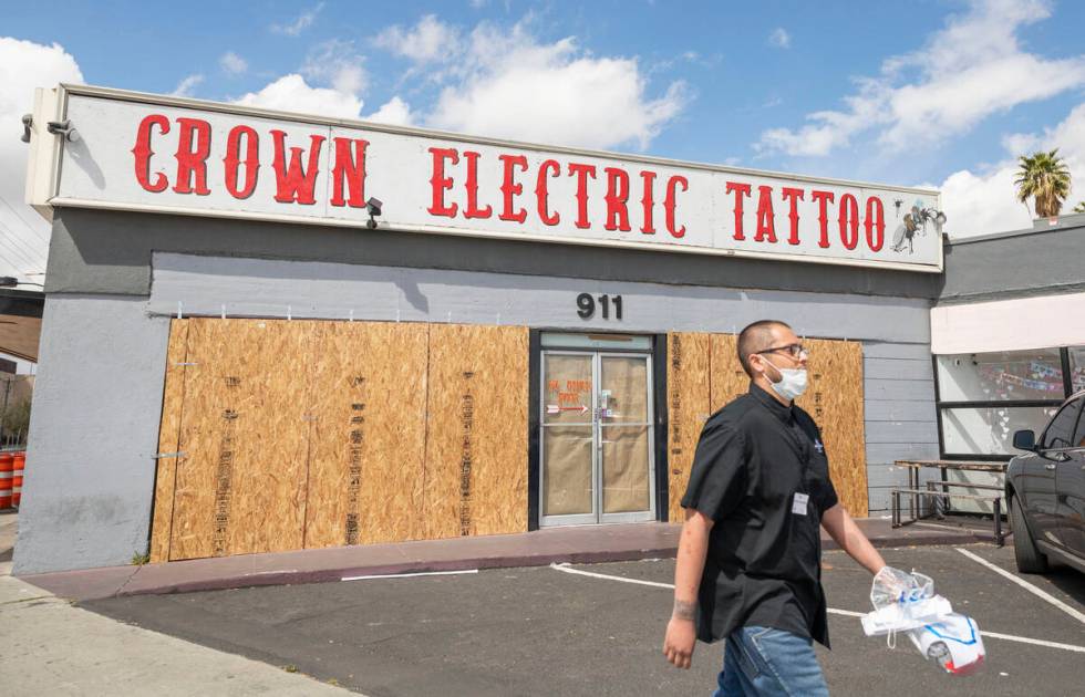 Surgio Aguirre of North Las Vegas walks by the recently boarded Crown Electric Tattoo Co. locat ...