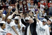 Connecticut head coach Jim Calhoun, holds the trophy and celebrates with his team after the NCA ...