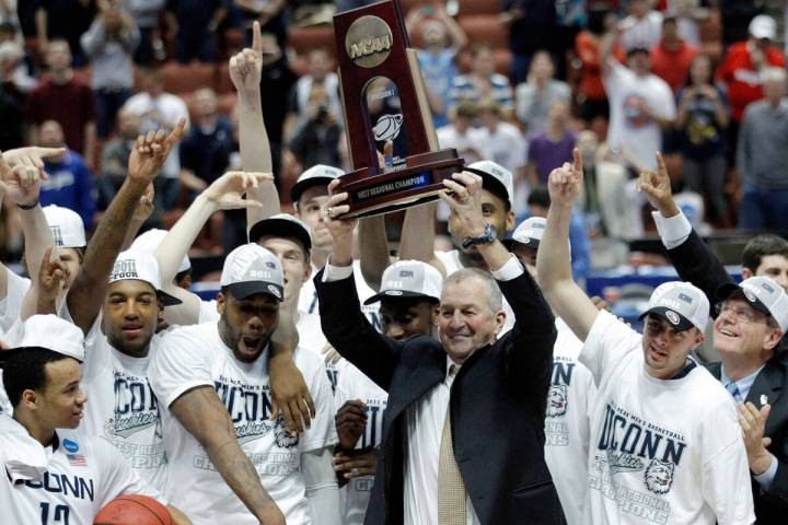 Connecticut head coach Jim Calhoun, holds the trophy and celebrates with his team after the NCA ...
