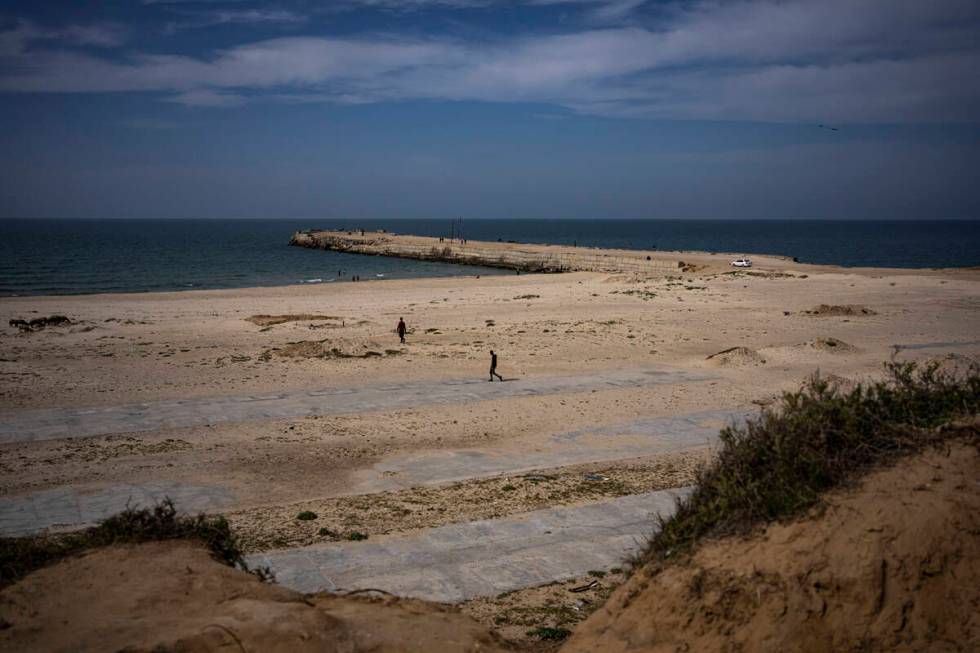 Palestinians walk by a pier that could be used to bring humanitarian aid to the Gaza Strip in K ...