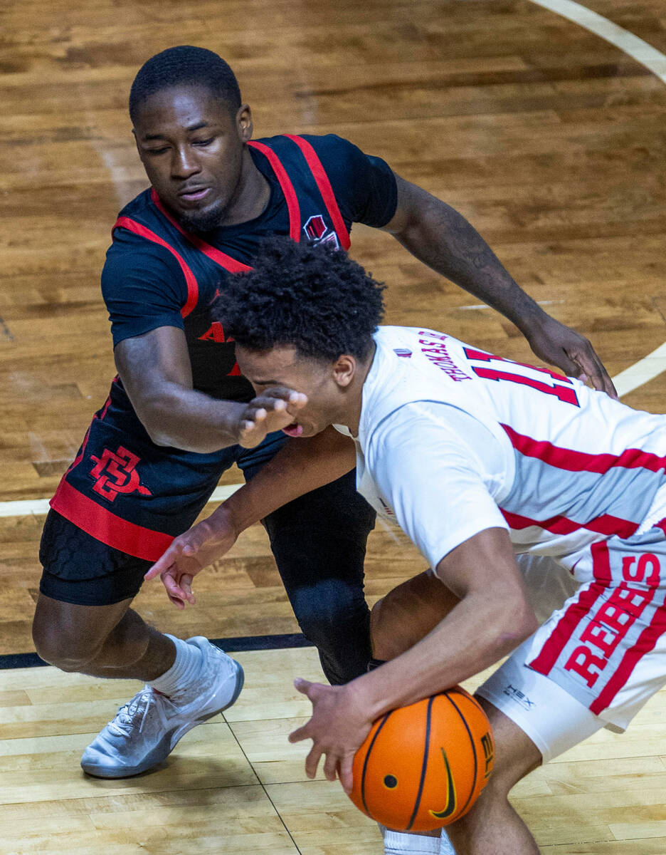 UNLV Rebels guard Dedan Thomas Jr. (11) takes a hand to the face but no foul called against San ...