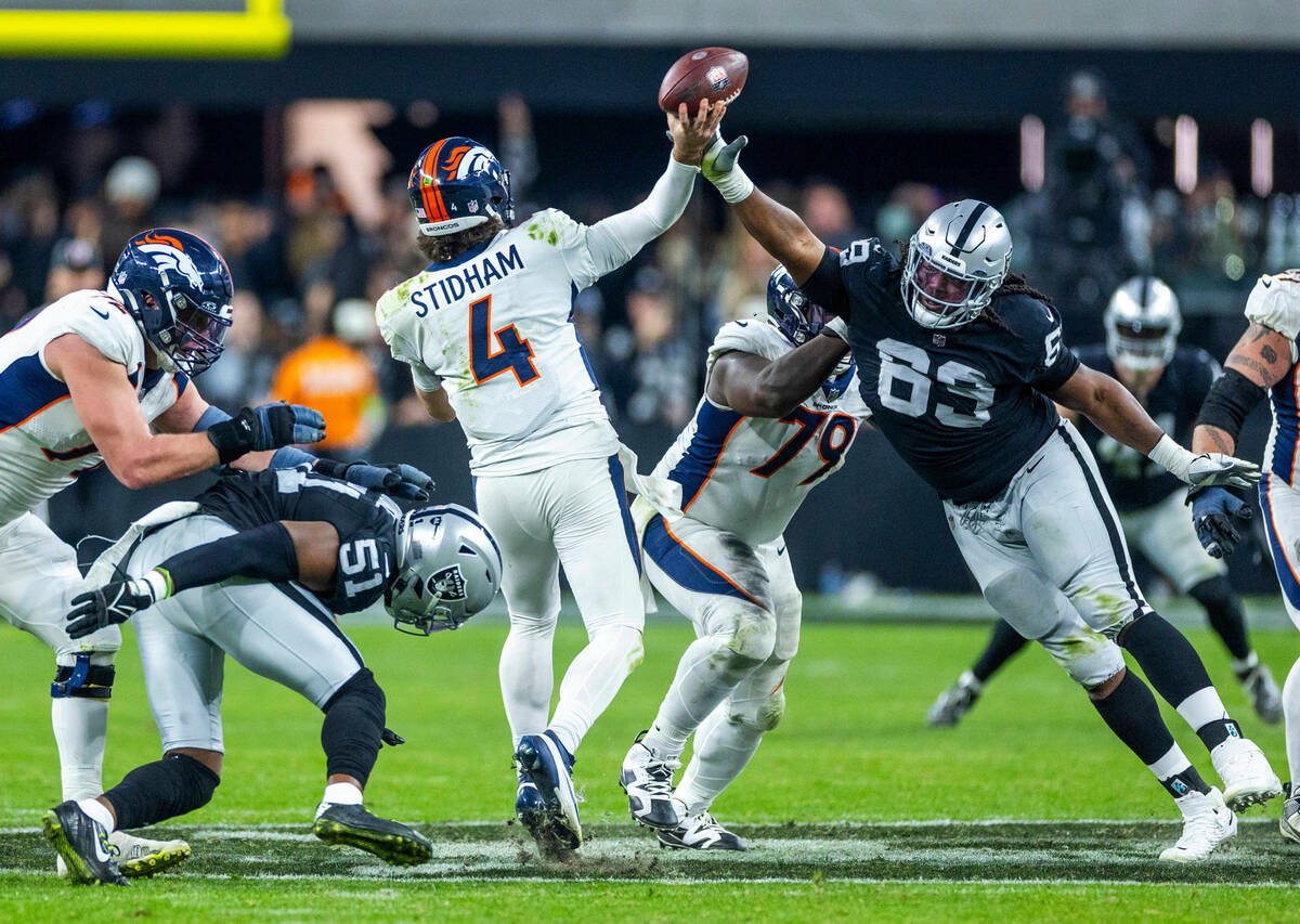 Denver Broncos quarterback Jarrett Stidham (4) has the ball tipped by Raiders defensive tackle ...