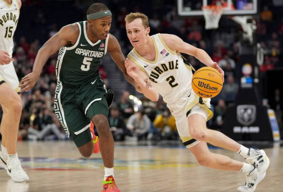 Purdue guard Fletcher Loyer (2) works toward the basket as Michigan State guard Tre Holloman (5 ...