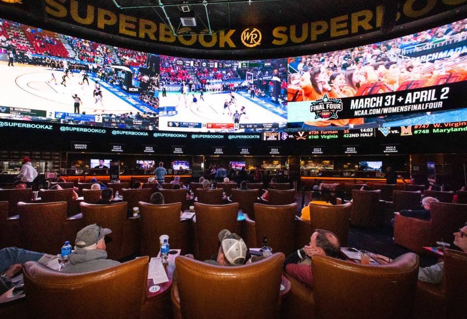 Guests watch on the big screens the first day of the NCAA basketball tournament at the Sports B ...