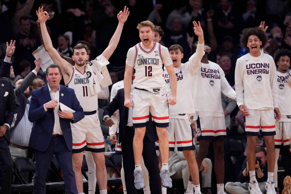 UConn guard Cam Spencer (12) and teammates celebrate during the final minutes of the team's NCA ...