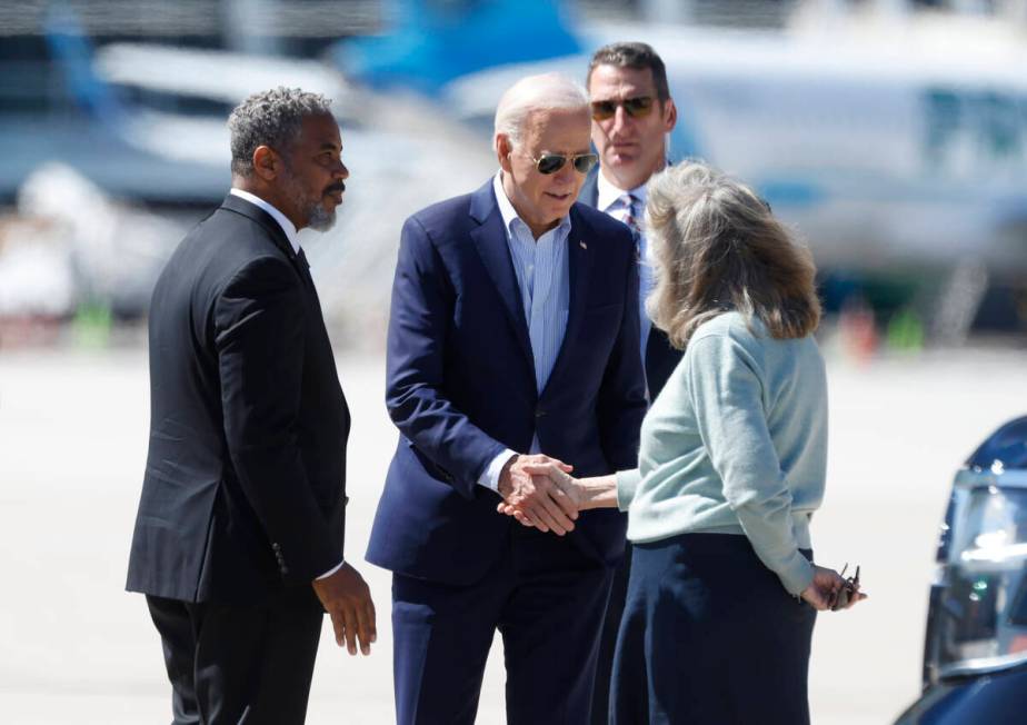 President Joe Biden is greeted by Rep. Steven Horsford, left, and Congresswoman Dina Titus afte ...