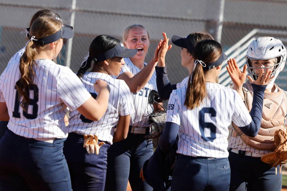 Shadow Ridge pitcher Josslin Law (4), center, and catcher Jacobi Gledill (13), right, get high ...