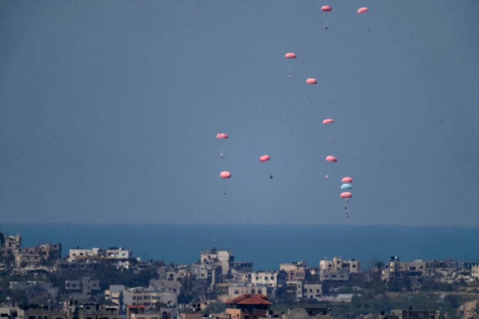 Parachutes drop supplies into the northern Gaza Strip, as seen from southern Israel, Wednesday, ...