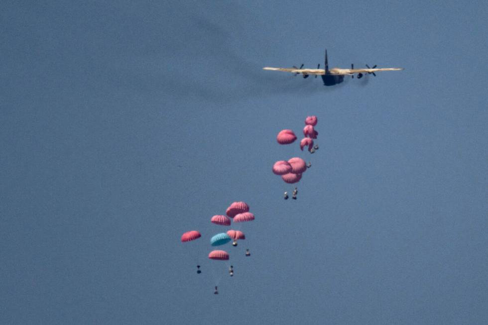 An aircraft airdrops humanitarian aid over northern Gaza Strip, as seen from southern Israel, W ...