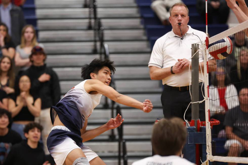 Coronado outside hitter Aiden Camacho spikes past the net for a point during a boys high school ...