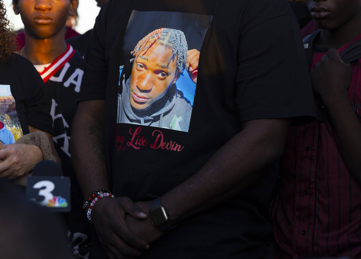 Raymond Heath, wearing a shirt depicting his son, Devin Heath, speaks during a vigil in his son ...