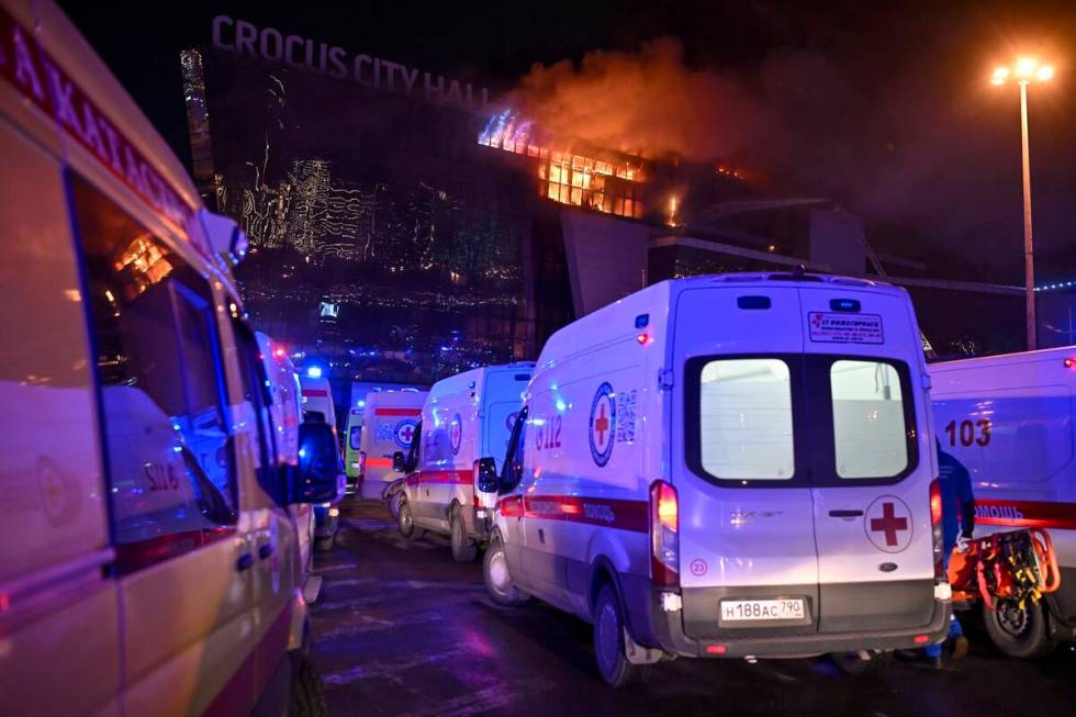 Ambulances park near a burning building of the Crocus City Hall on the western edge of Moscow, ...