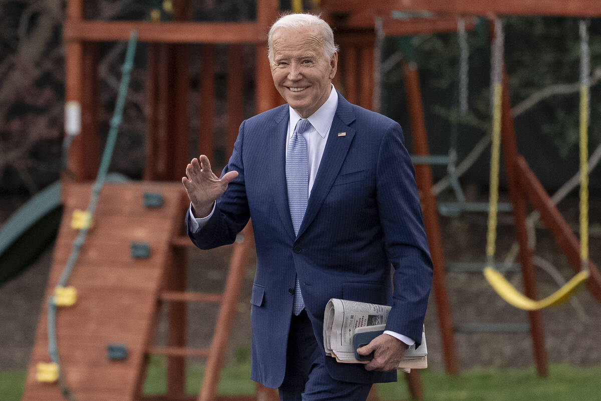 President Joe Biden waves to members of the media as he walks toward Marine One on the South La ...