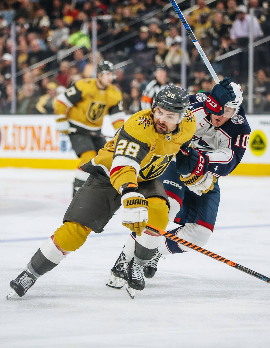 Golden Knights left wing William Carrier (28) pushes off Columbus Blue Jackets left wing Dmitr ...