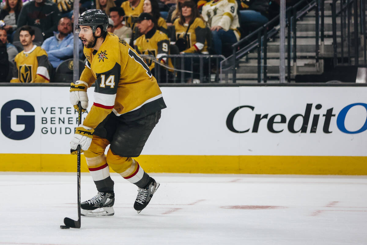 Golden Knights defenseman Nicolas Hague (14) shuffles the puck down the ice during an NHL hocke ...