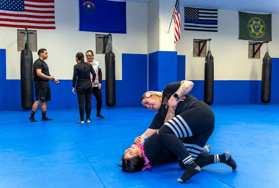 Attendee Serena Moran, top, does a sweep takedown maneuver on parter Claudia Martinez as the tw ...