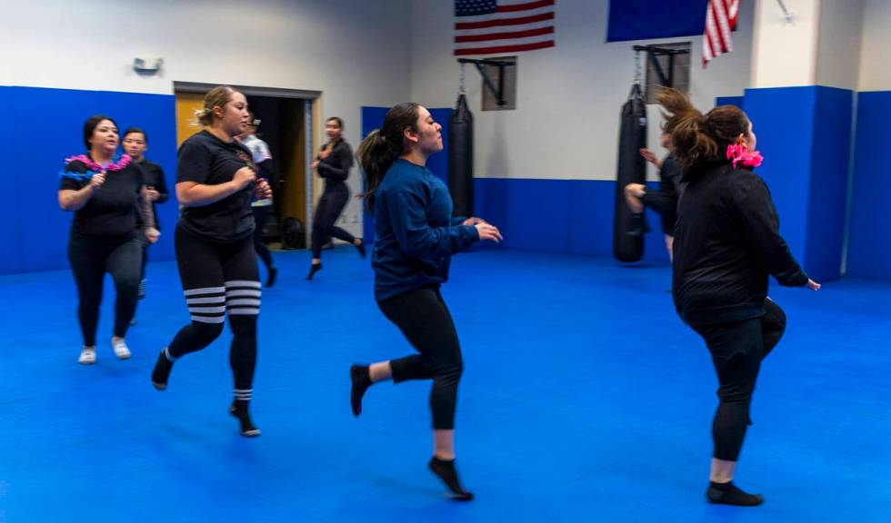 Attendees do warm up exercises before learning defensive tactics with the Metro recruiting depa ...