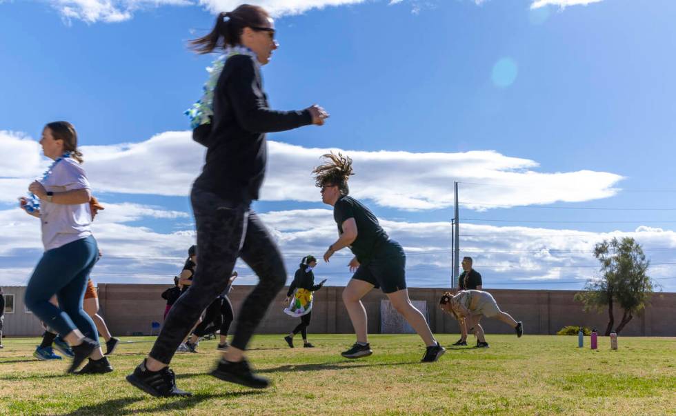 Attendees run sprints and do burpees as women participate in an outside circuit work out with t ...