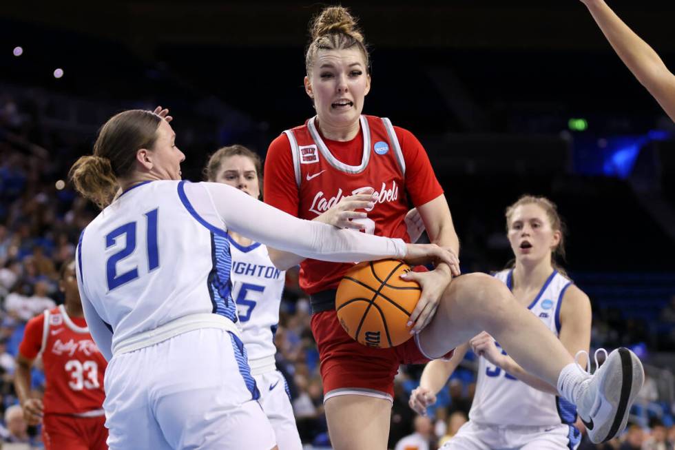 UNLV Lady Rebels guard Ashley Scoggin, center, struggles for a rebound against Creighton Blueja ...