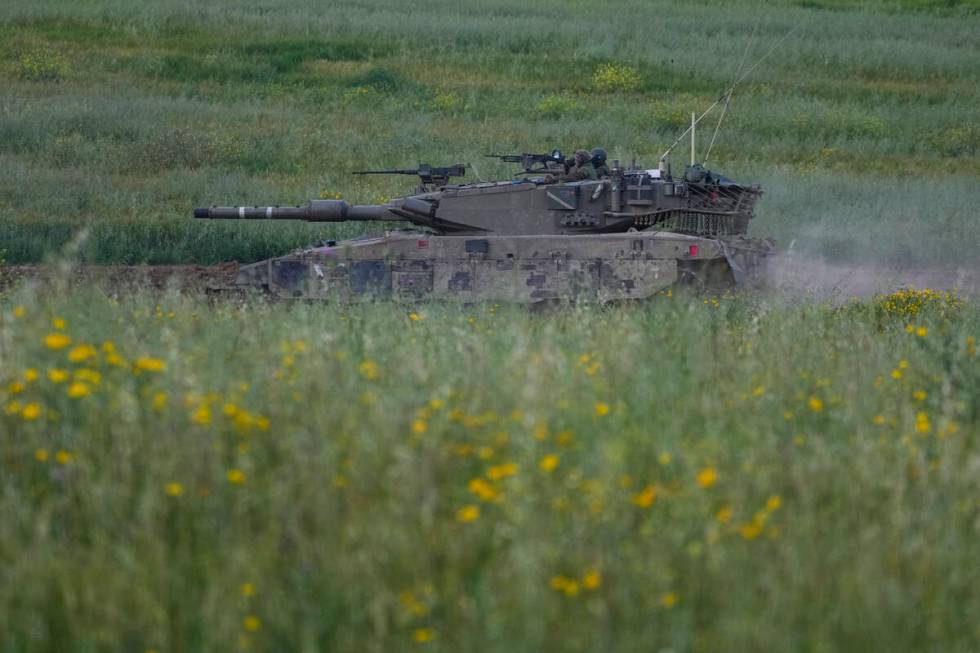 Israeli soldiers drive a tank in southern Israel, near the border with the Gaza Strip, Sunday, ...