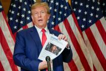 FILE - Former President Donald Trump holds up a copy of a story featuring New York Attorney Gen ...