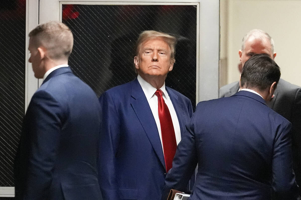 Former President Donald Trump, center, leaves a pre-trial hearing during a recess with his defe ...