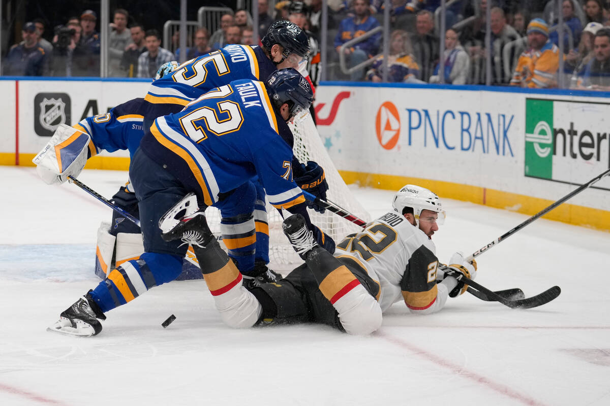 Vegas Golden Knights' Michael Amadio (22) falls as St. Louis Blues' Justin Faulk (72) and Colto ...