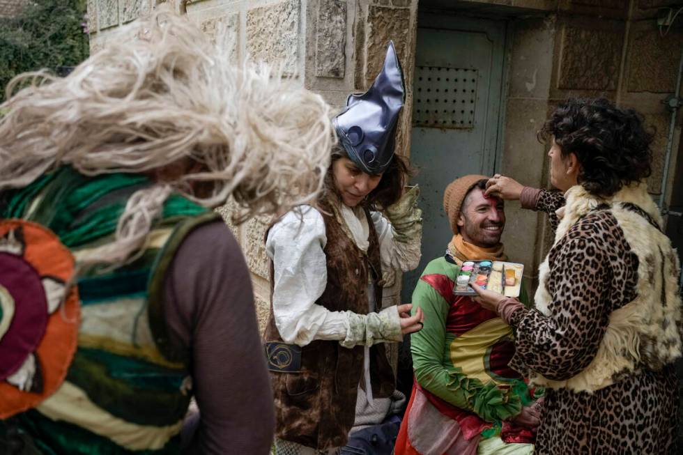 Performers apply makeup ahead of the Purim parade in Jerusalem, Monday, March 25, 2024. (AP Pho ...