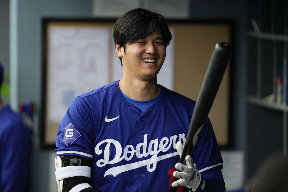 Los Angeles Dodgers designated hitter Shohei Ohtani (17) prepares his bat in the dugout during ...