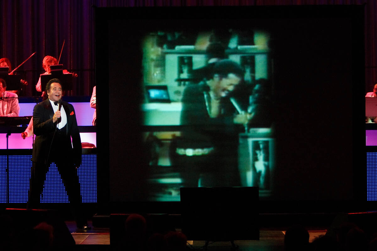 Entertainer Wayne Newton performs next to a video image of Sammy Davis Jr. during the opening n ...