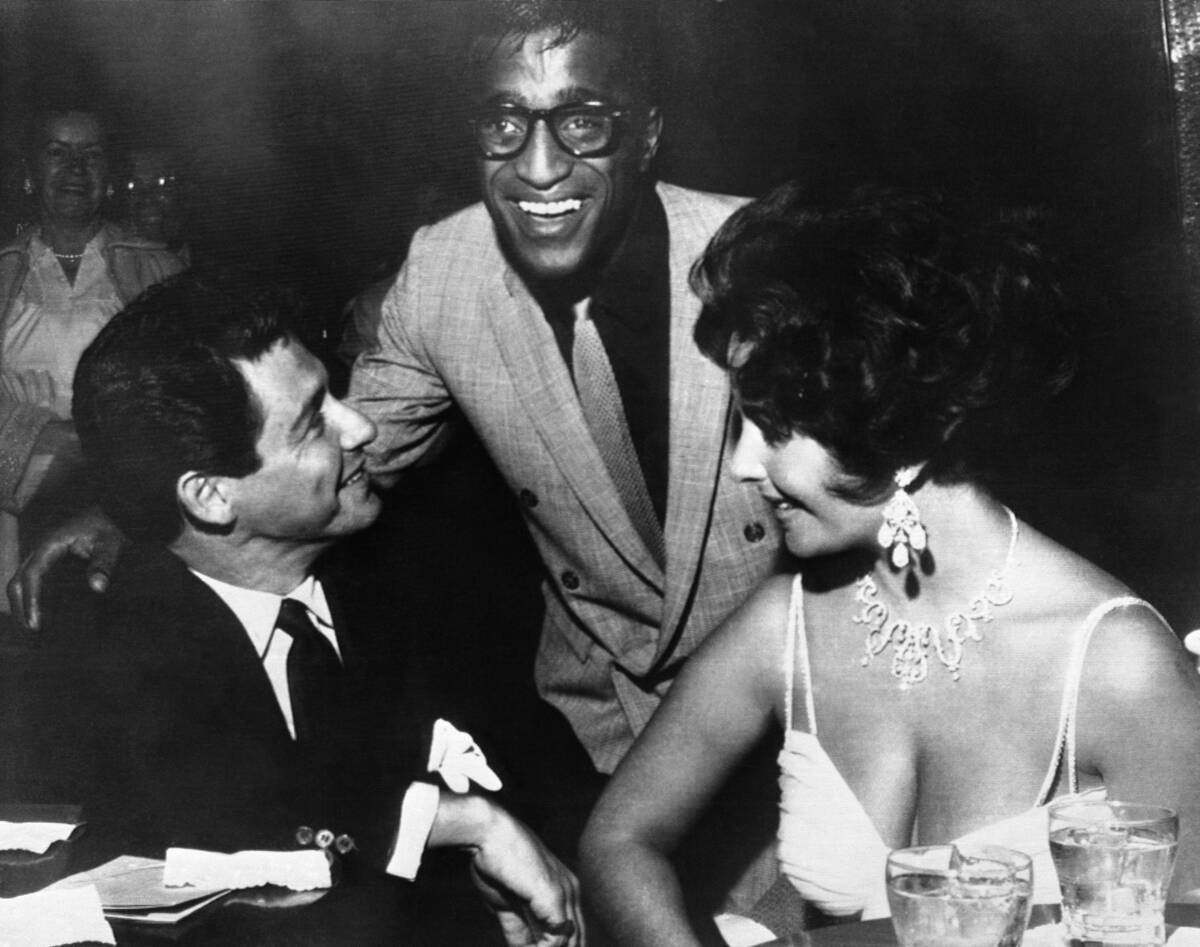 Elizabeth Taylor, right, and Eddie Fisher, left, discuss wedding plans with Sammy Davis, Jr. sh ...