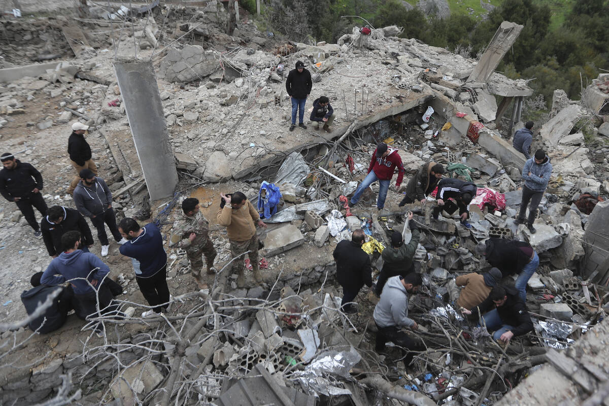 People search for victims in the rubble of a paramedic center that was destroyed by an Israeli ...