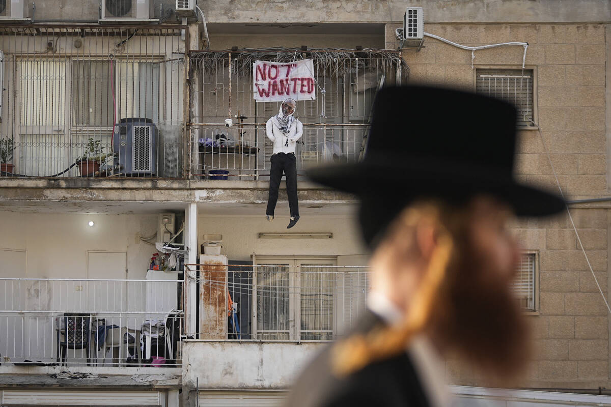 An effigy of Hamas leader Yehya Sinwar hangs off the balcony of an apartment under the sign &qu ...