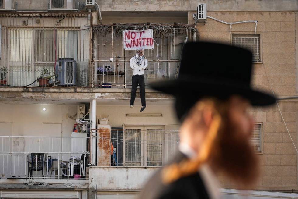 An effigy of Hamas leader Yehya Sinwar hangs off the balcony of an apartment under the sign &qu ...