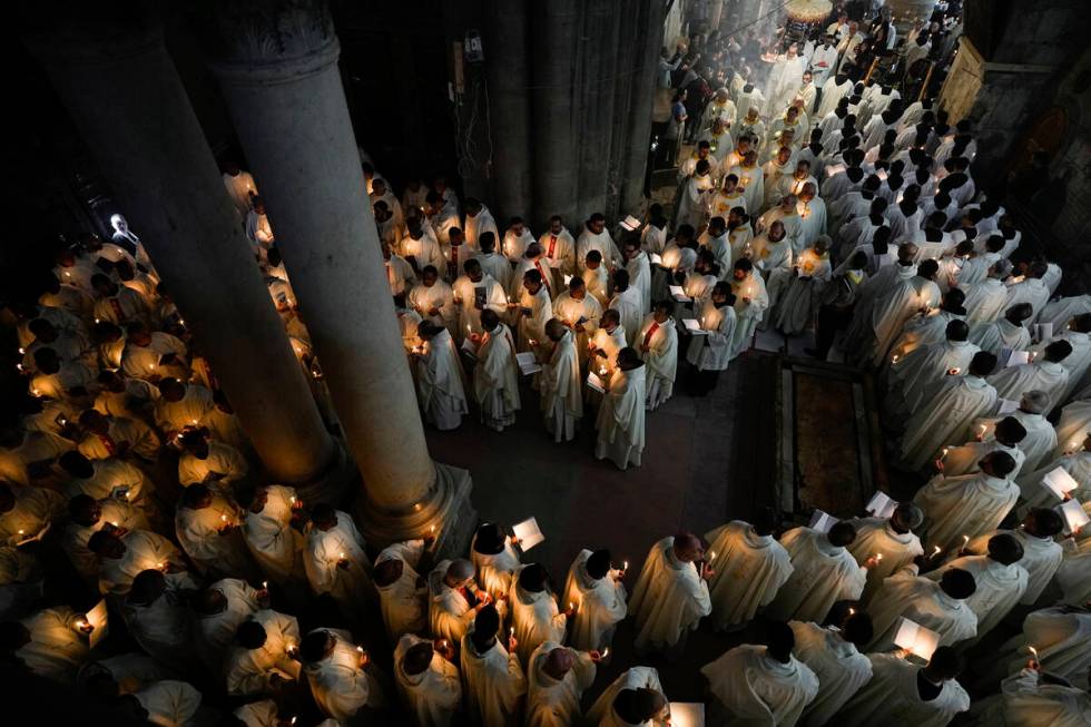 Catholic clergy hold candles as they walk during the Washing of the Feet procession at the Chur ...