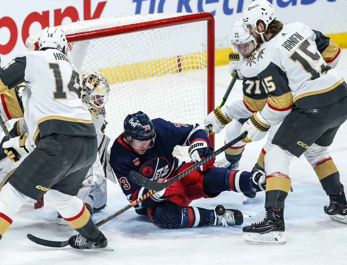 Winnipeg Jets' Tyler Toffoli gets hit by a shot in front of Vegas Golden Knights goaltender Log ...