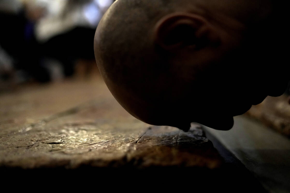 A Christian worshipper kisses the Stone of Unction, the stone slab traditionally claimed as the ...