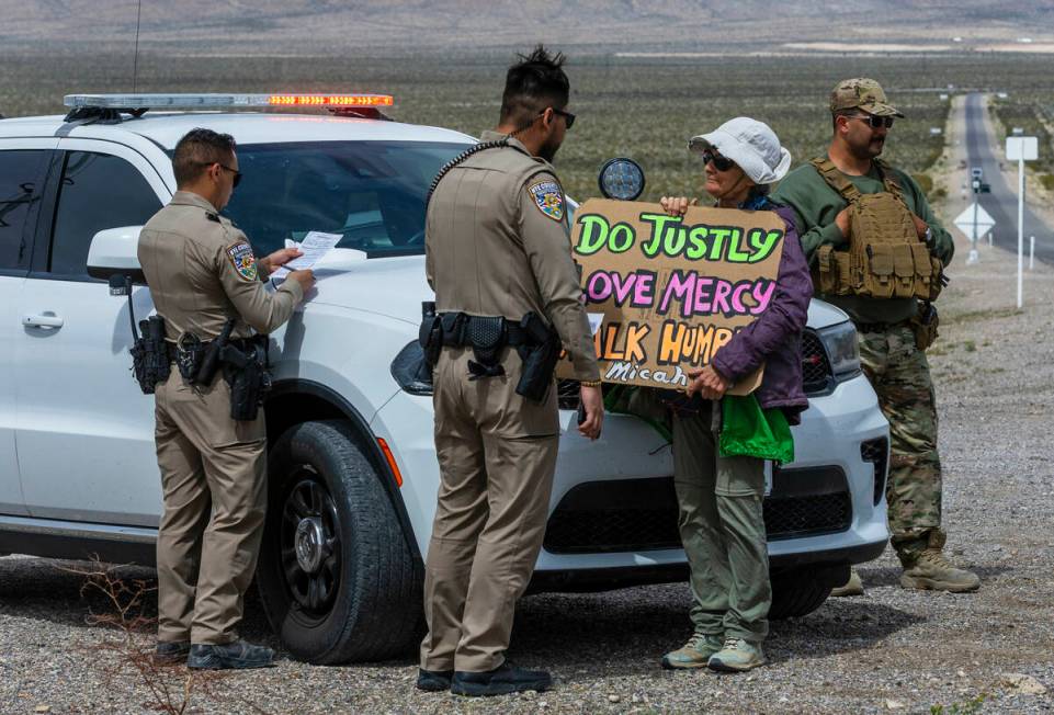 Beth Blattenberger, center, stands beside officers awaiting a citation after trespassing onto t ...