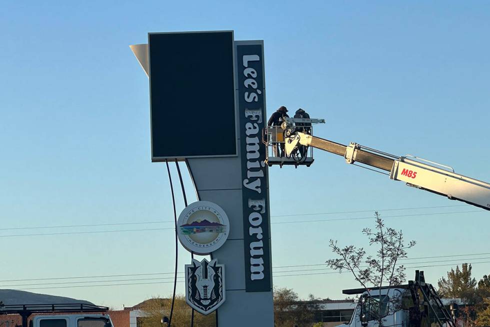 Workers update signage at Lee's Family Forum, the Henderson arena formerly named Dollar Loan Ce ...