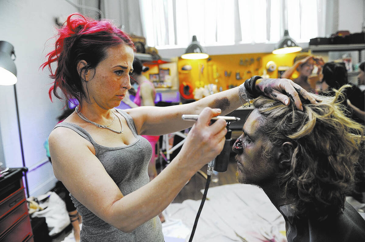 Kelly “Red” Belmonte, star of “Naked Vegas” on the Syfy channel, paints the face of “ ...