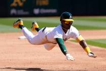 Oakland Athletics' Esteury Ruiz slides into third base after hitting a triple during the third ...