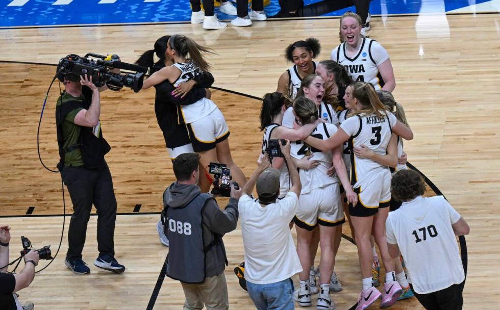 Iowa players celebrate after Iowa defeated LSU in an Elite Eight round college basketball game ...