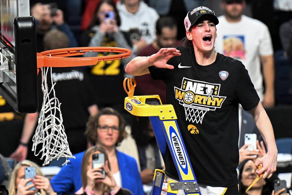 Iowa guard Caitlin Clark reacts to the crowd before cutting a piece of the net after Iowa defea ...