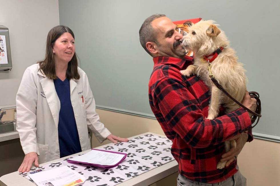 In this image provided by Corinne Martin, Mehrad Houman holds his dog, Mishka, after she was ex ...