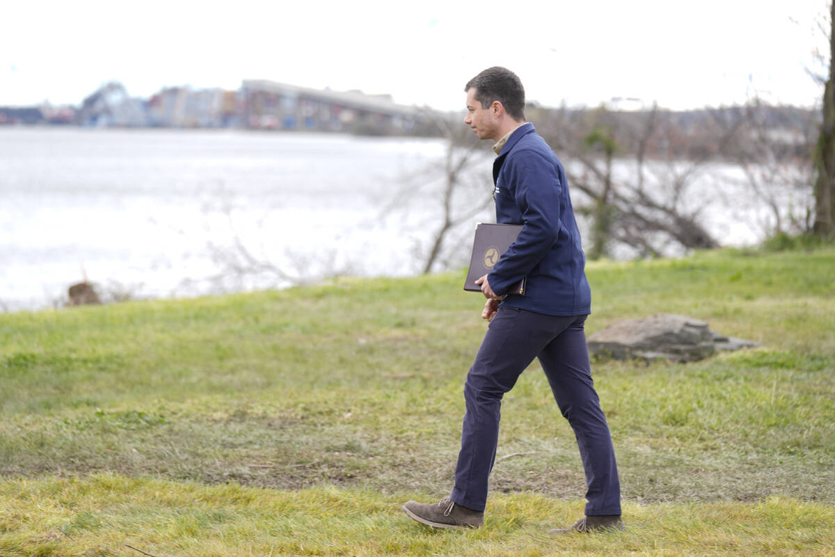 Transportation Secretary Pete Buttigieg, with the collapsed Francis Scott Key Bridge, seen rear ...