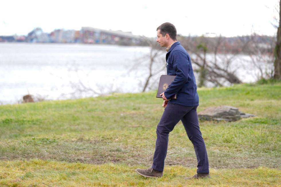 Transportation Secretary Pete Buttigieg, with the collapsed Francis Scott Key Bridge, seen rear ...