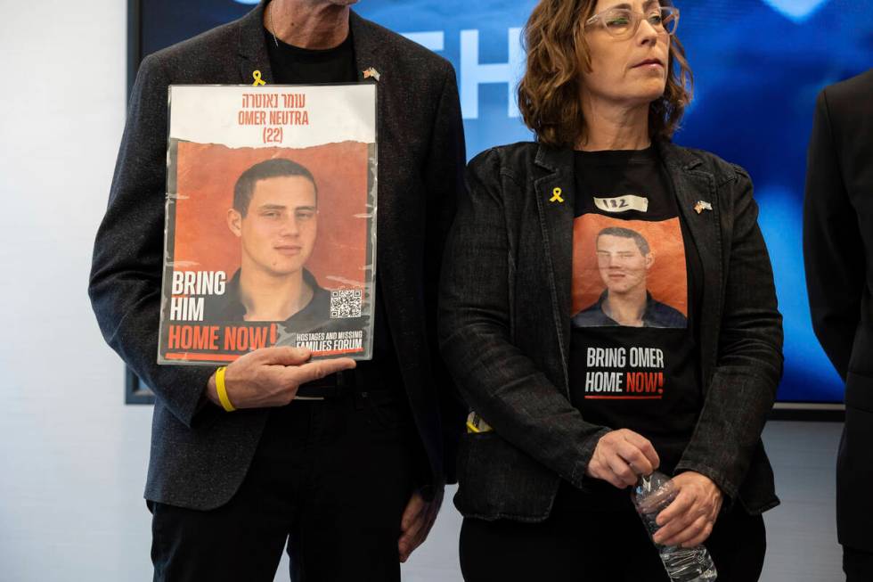 Ronen and Orna Neutra, parents of American hostage Omer Neutra, hold signs of their son during ...